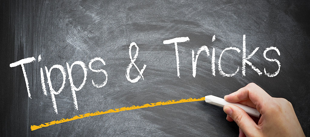 Mann scheibt "Tipps & Tricks" auf Tafel
